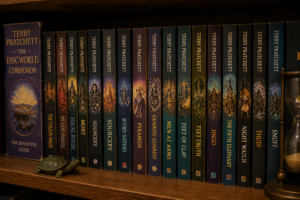 Estantería de madera con colección de libros de la saga Mundodisco de Terry Pratchett, con lomos ilustrados y ambientación cálida tipo biblioteca.